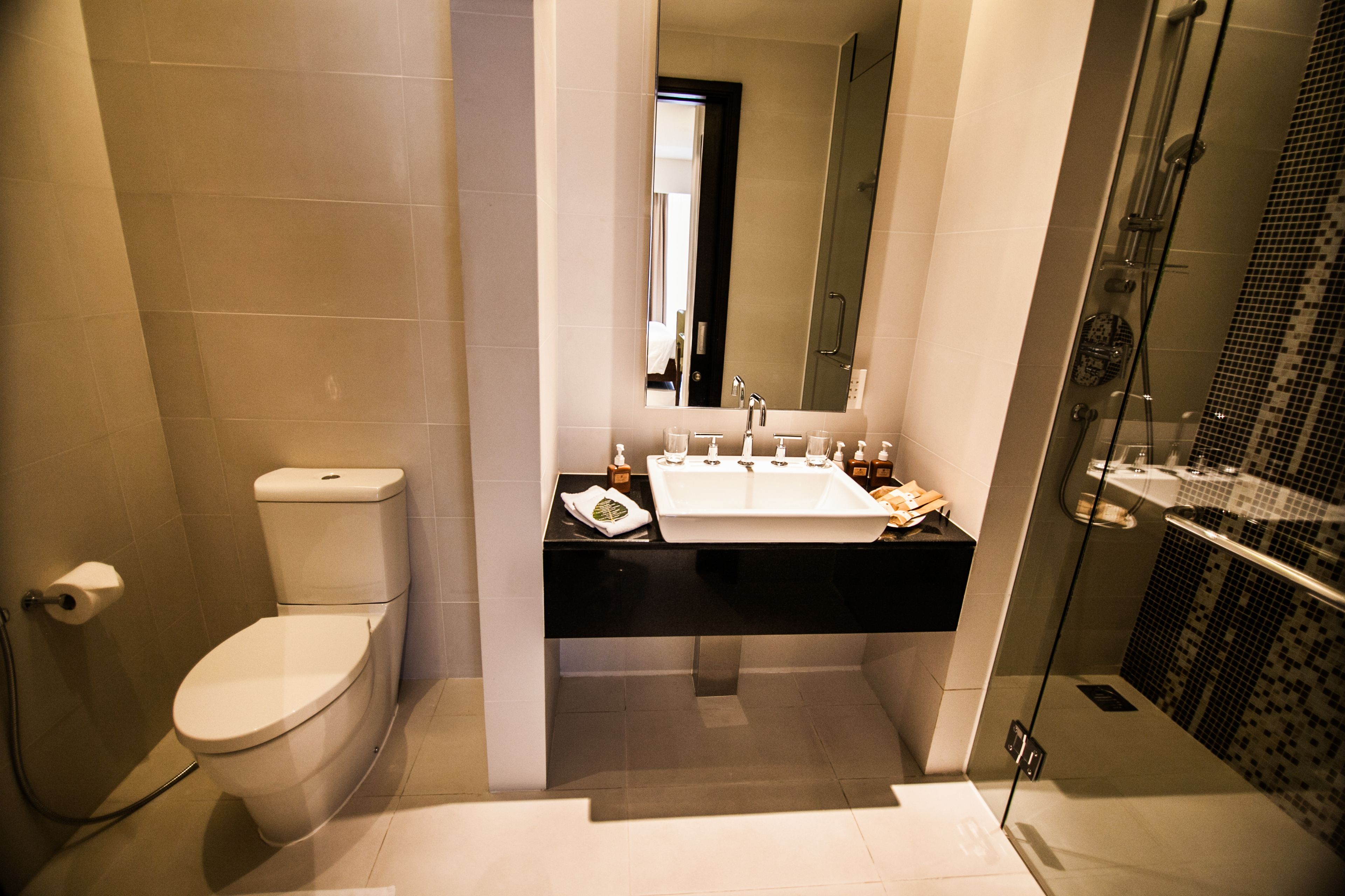 Une salle de bain moderne équipée de toilettes, d’un lavabo et d’une douche.