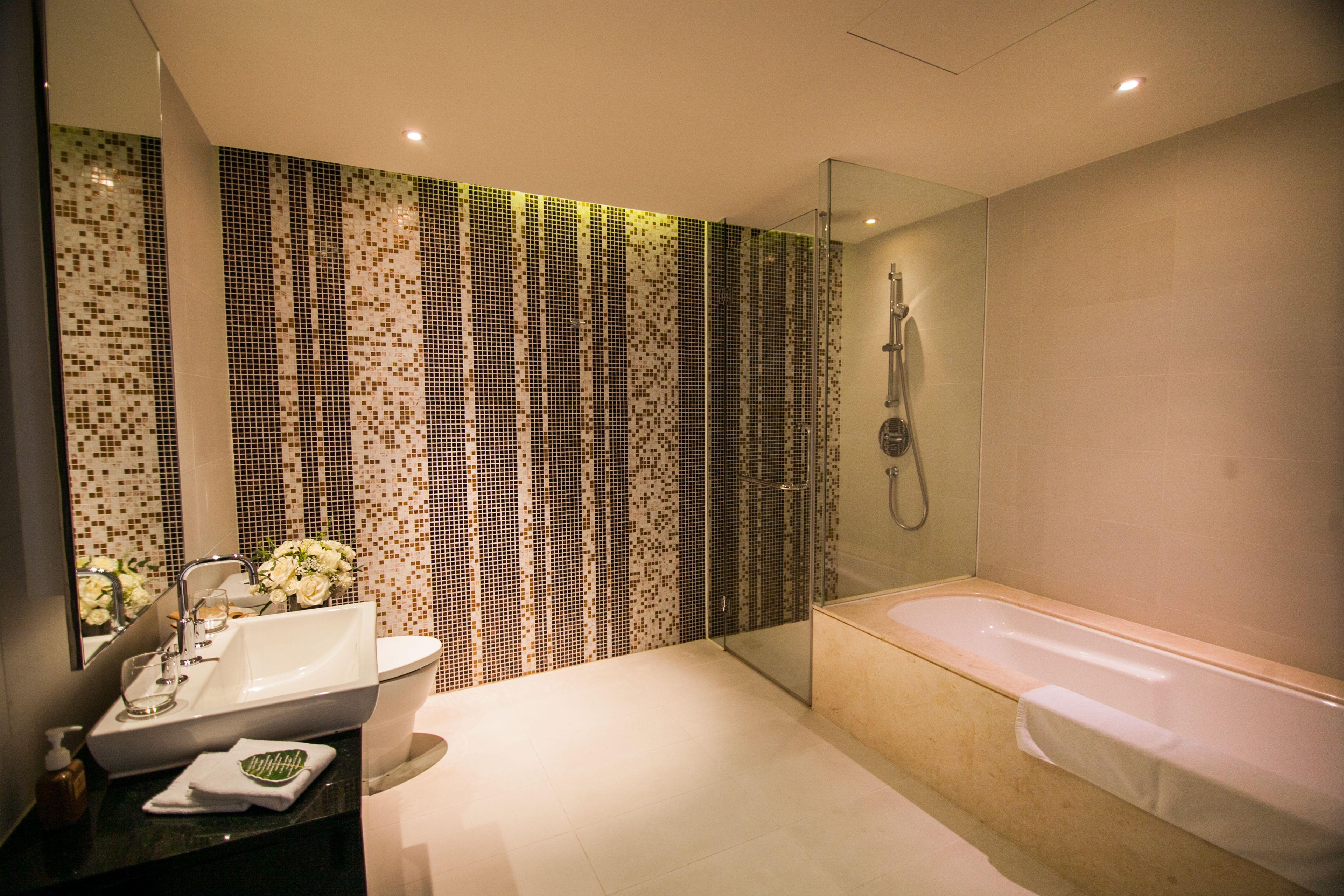 Ein modernes Badezimmer mit einer großen Badewanne, einer Duschkabine und einem Waschbecken mit Spiegel.