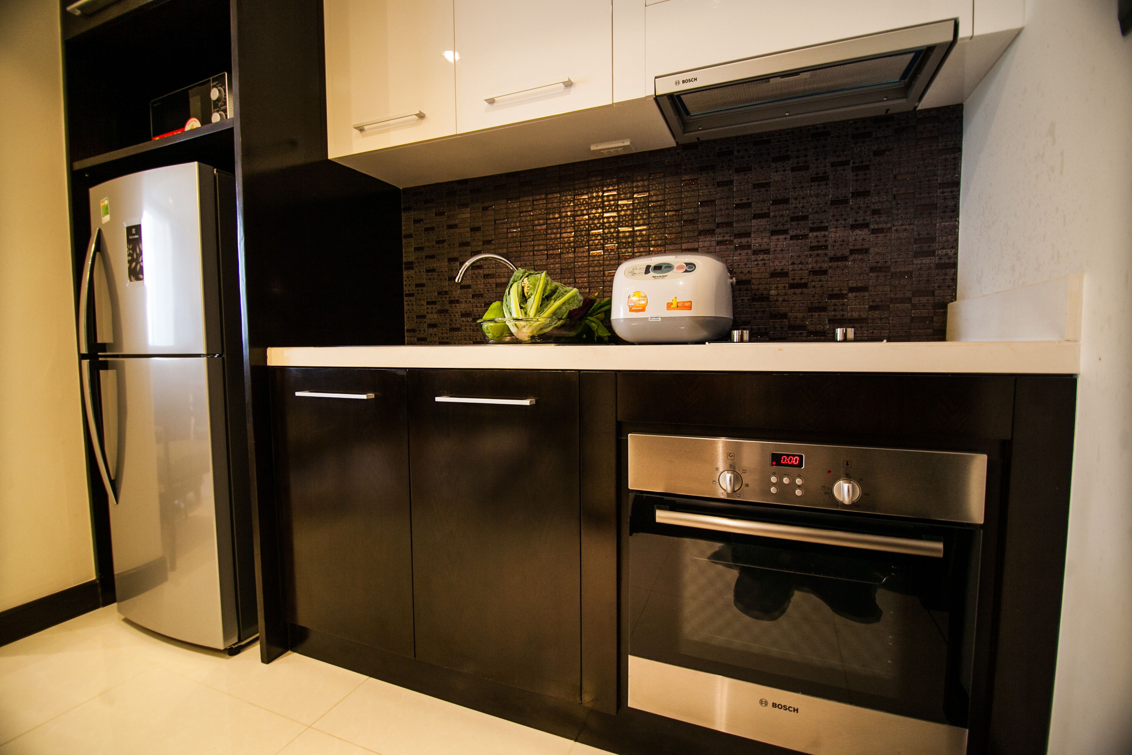 A modern kitchen with a Bosch refrigerator, oven, and toaster.