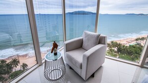 Une chambre moderne dotée d’une grande fenêtre donnant sur la plage et l’océan.
