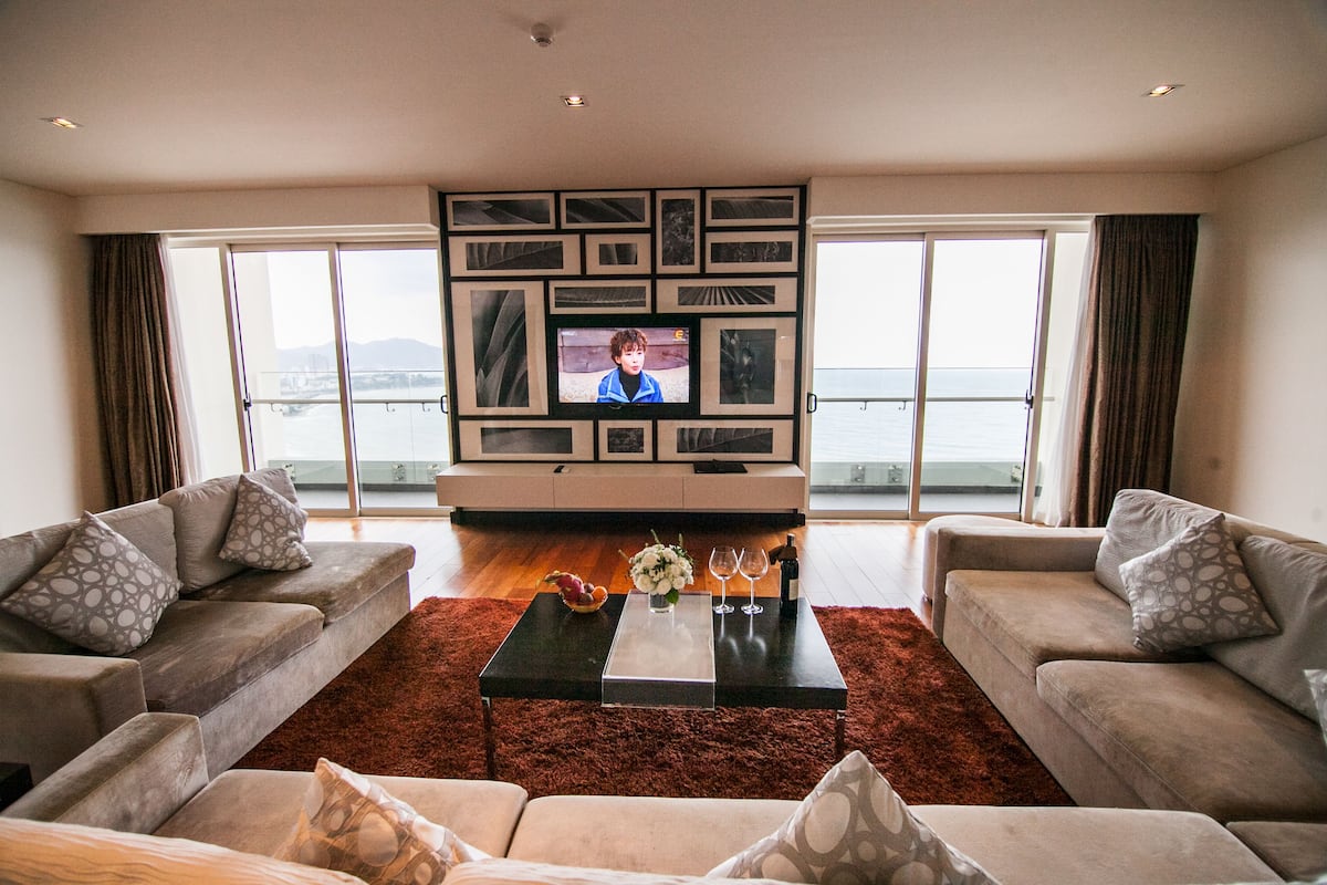 Een woonkamer met twee banken, een salontafel en een televisiescherm.