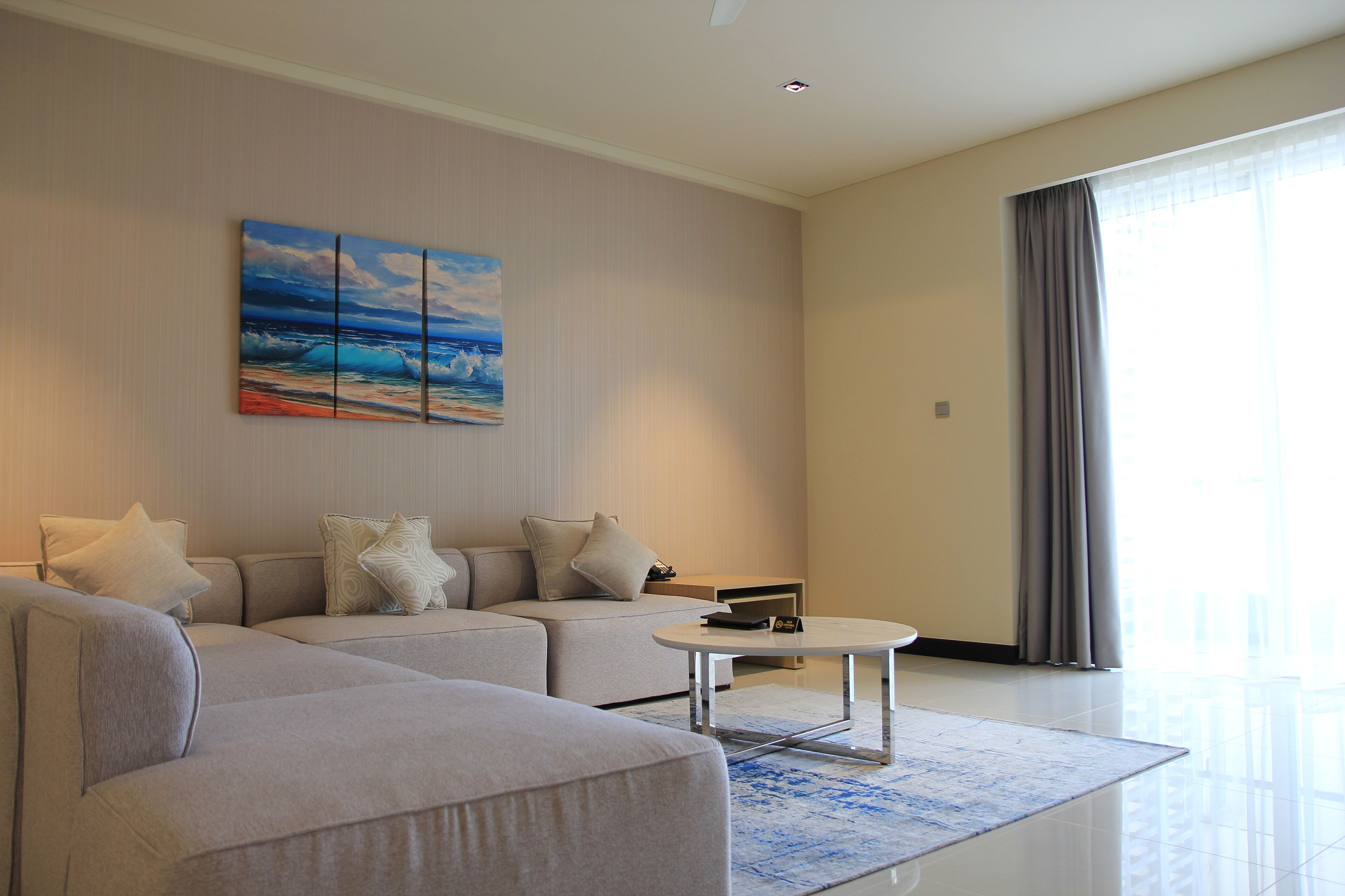Una sala moderna con un sofá modular, una mesita de centro y un cuadro en la pared.