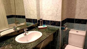A bathroom with a sink, mirror, and toilet.