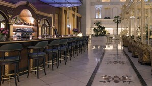 A hotel lobby with a bar area, seating, and a decorative ceiling. - Rixos Khadisha Shymkent (Shymkent)