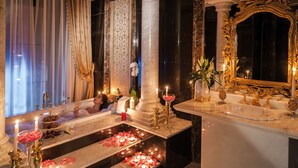 A luxurious bathroom with marble countertops, a large mirror, and decorative candles. - Rixos Khadisha Shymkent (Shymkent)