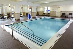 A large indoor swimming pool with a 3ft depth limit, surrounded by chairs and a pool lift.