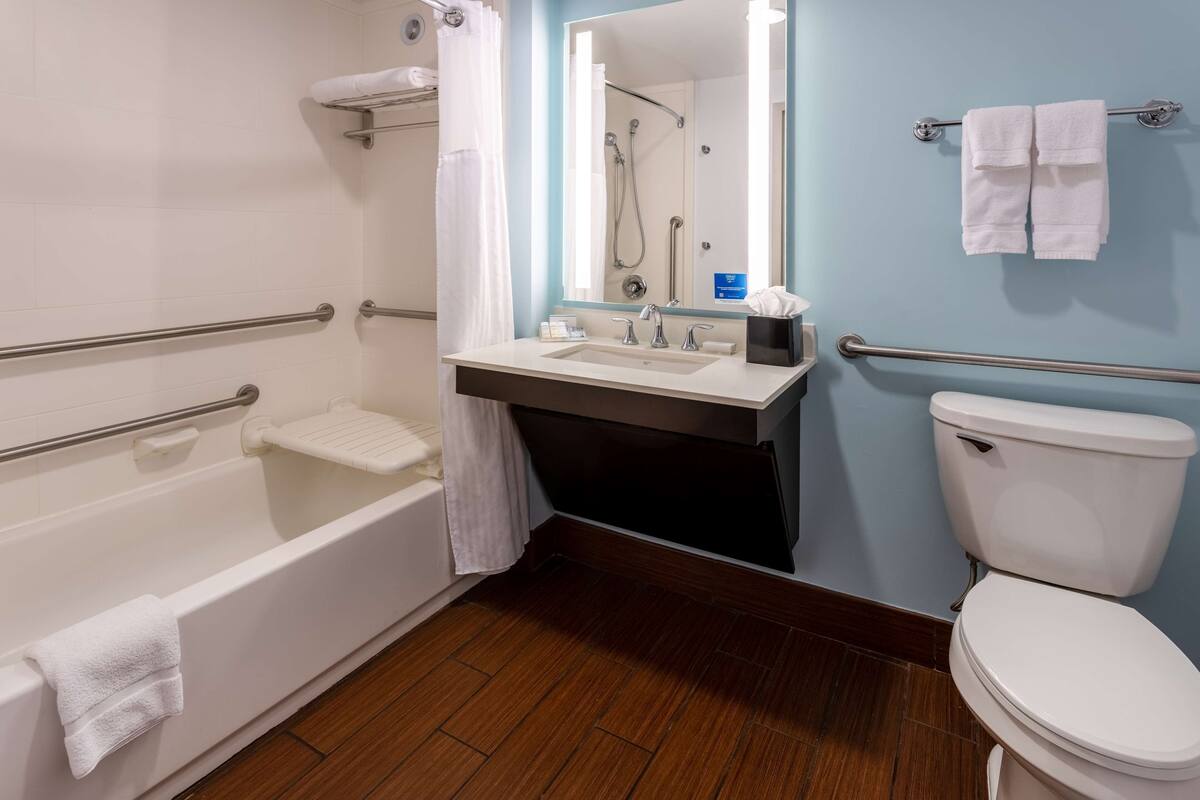 A modern bathroom with a bathtub, toilet, and sink.