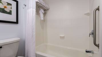 A bathroom with a white toilet, a bathtub, and a shower curtain.