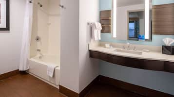 Een moderne badkamer met een badkuip, een wastafel en een spiegel.