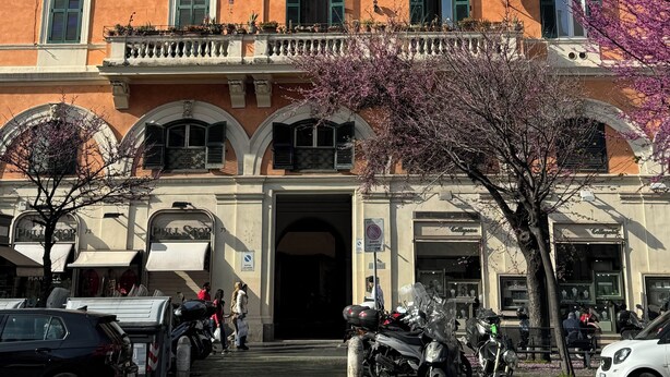 A multi-story building with a uniform facade, large windows with shutters, and a central entrance with a canopy. - Relais Cola di Rienzo (Rome)