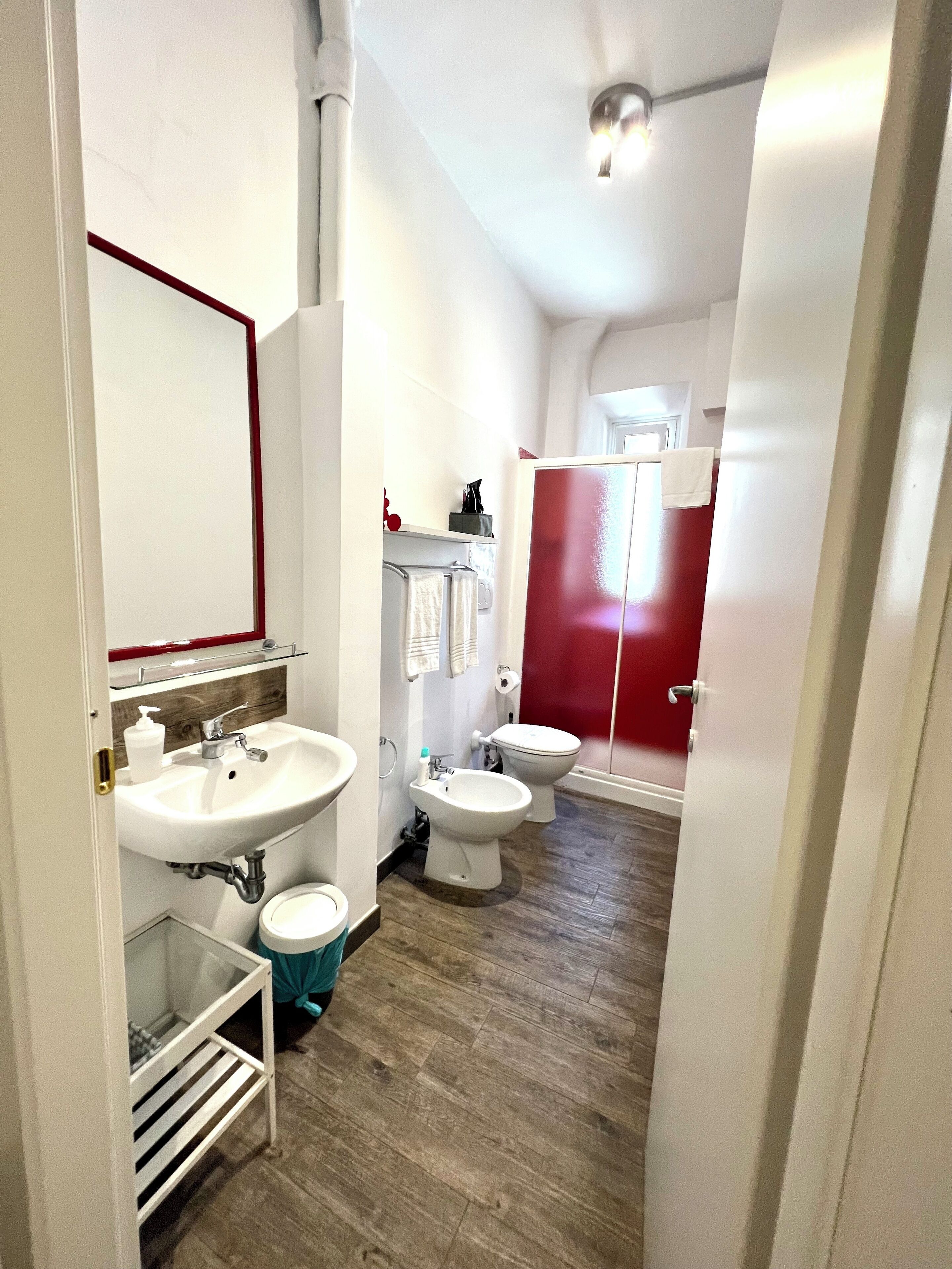 Une petite salle de bain comprenant un lavabo, deux toilettes et un espace douche.