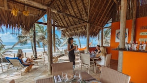 Un restaurant situé en bord de mer, avec une terrasse, une vue sur l’océan et un bar bien approvisionné.