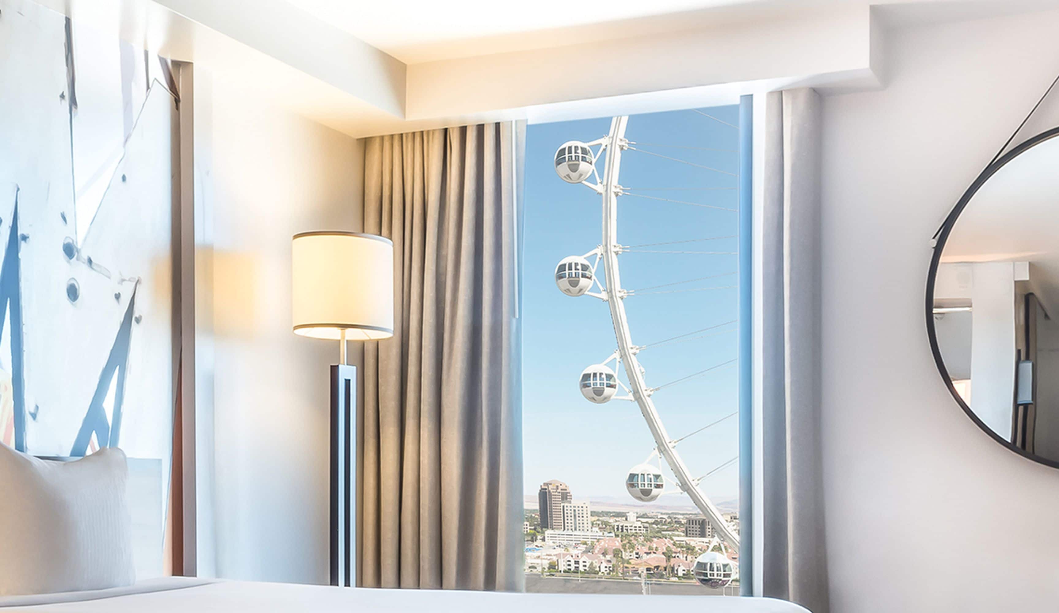 Une chambre d’hôtel avec une grande fenêtre, une lampe et une vue sur une grande roue.