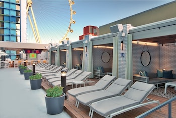 A hotel with a prominent Ferris wheel, multiple casino signs, and a distinctive hexagonal facade. at The LINQ Hotel & Casino – A Caesars Rewards Destination