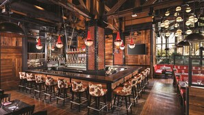 A bar area with a long counter, multiple stools, and a brick wall backdrop. - The LINQ Hotel & Casino – A Caesars Rewards Destination (Las Vegas)