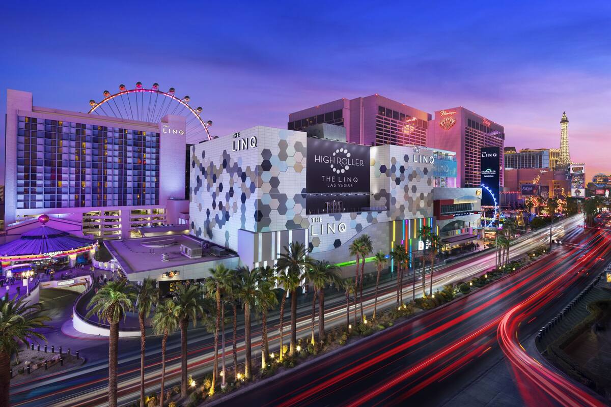 A hotel with multiple floors, a prominent Ferris wheel, and a casino area with bright lights.