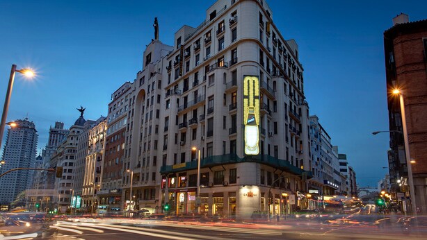 A historic building with multiple floors, large windows, and a prominent corner entrance. - Hostal Besaya (Madrid)