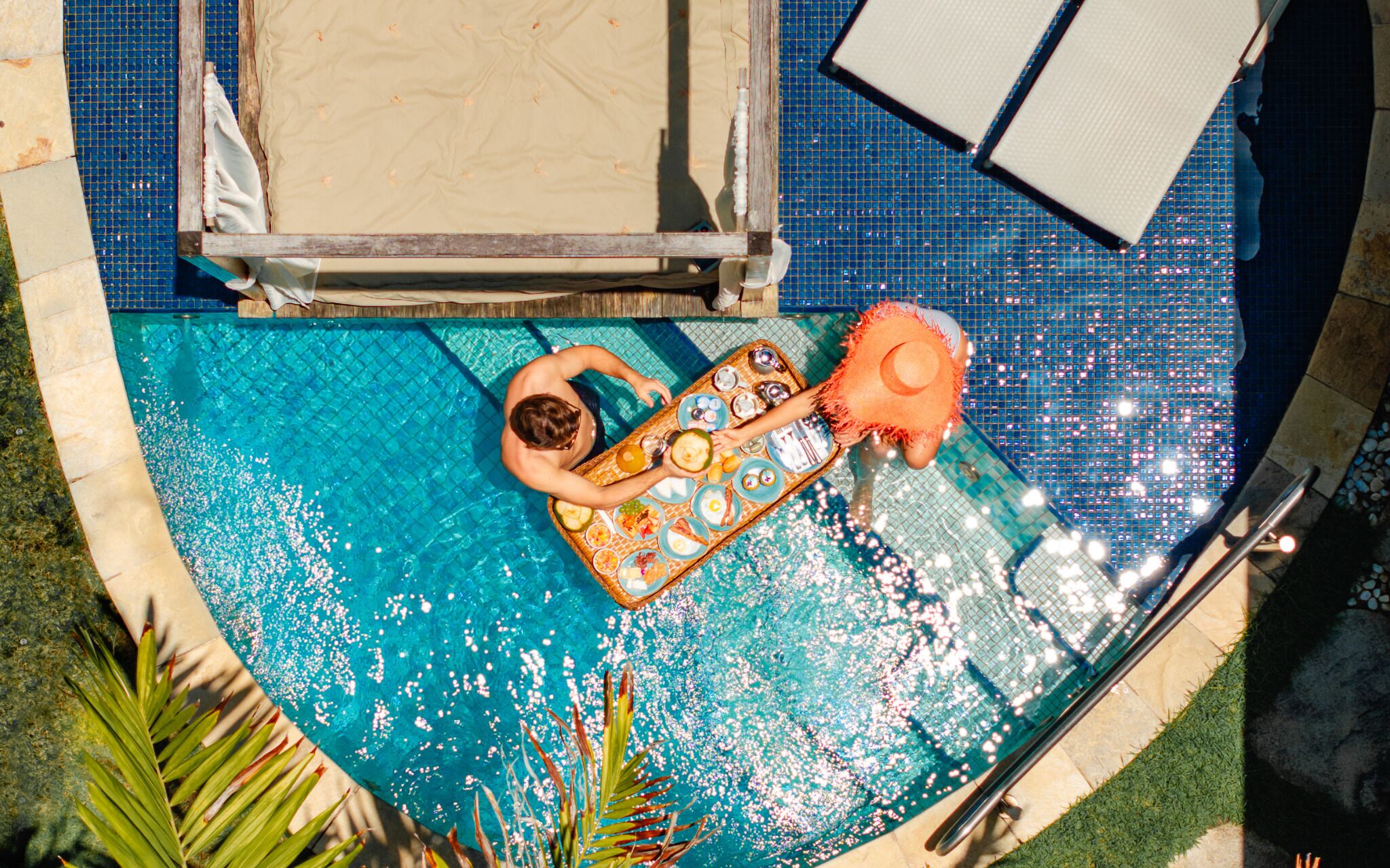 Piscina com espreguiçadeira e espreguiçado.