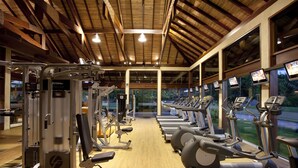 A gym with various exercise machines, large windows, and a wooden ceiling. - NANNAI Muro Alto (Ipojuca)