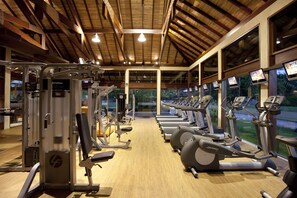 A gym with various exercise machines, large windows, and a wooden ceiling. - NANNAI Muro Alto (Ipojuca)