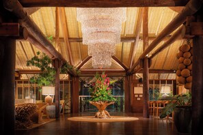 A spacious lobby with a high ceiling, a central wooden tree sculpture, and a hanging chandelier. - NANNAI Muro Alto (Ipojuca)