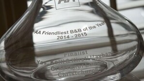 Un jarrón de cristal transparente con grabado que indica que es finalista para el premio al B&B más amable AA del año 2014-2015.