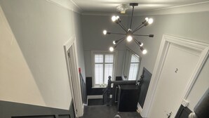 Una escalera conduce a un rellano con una lámpara en el techo y una puerta con el número 2.