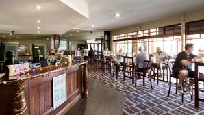 A spacious hotel lobby with a reception desk, seating area, and large windows. - Boomerang Hotel (Lavington)