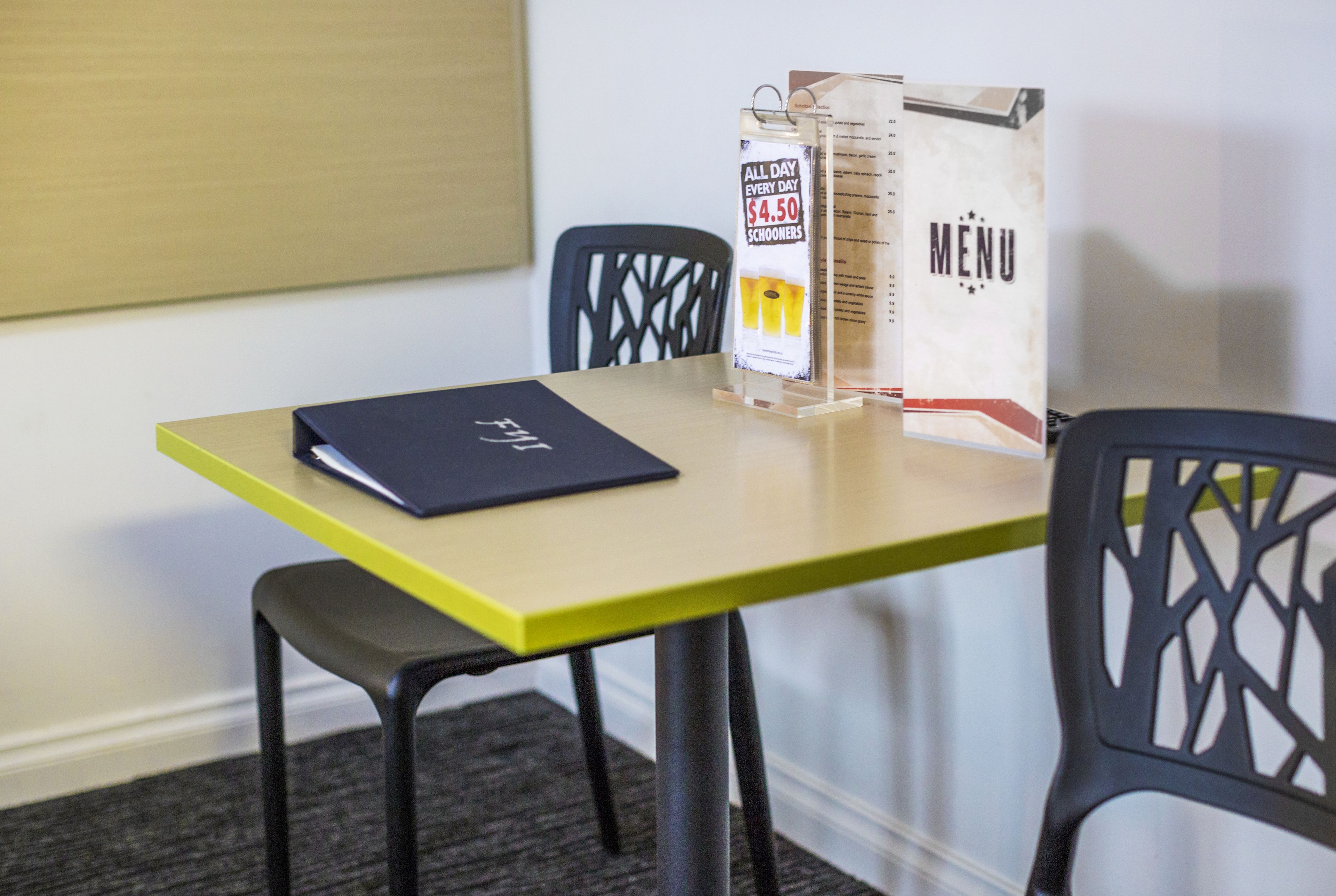 A table with a menu stand and a laptop.
