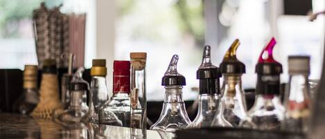 A bar with various bottles and glasses, reflecting on the surface.
