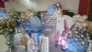 A baby shower setup with balloons, a large sign reading "BABY Evan," and decorative elements like a rabbit illustration and metallic decorations.