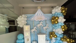A baby shower setup with a carousel and balloons.