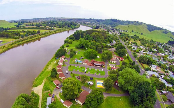 Une vue aérienne d’un village riverain, avec ses maisons, une piscine et un petit parc.
