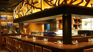 Zona de bar con sillas de madera y una barra.