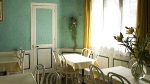 A dining area with a table and chairs, a door, and a window with curtains.
