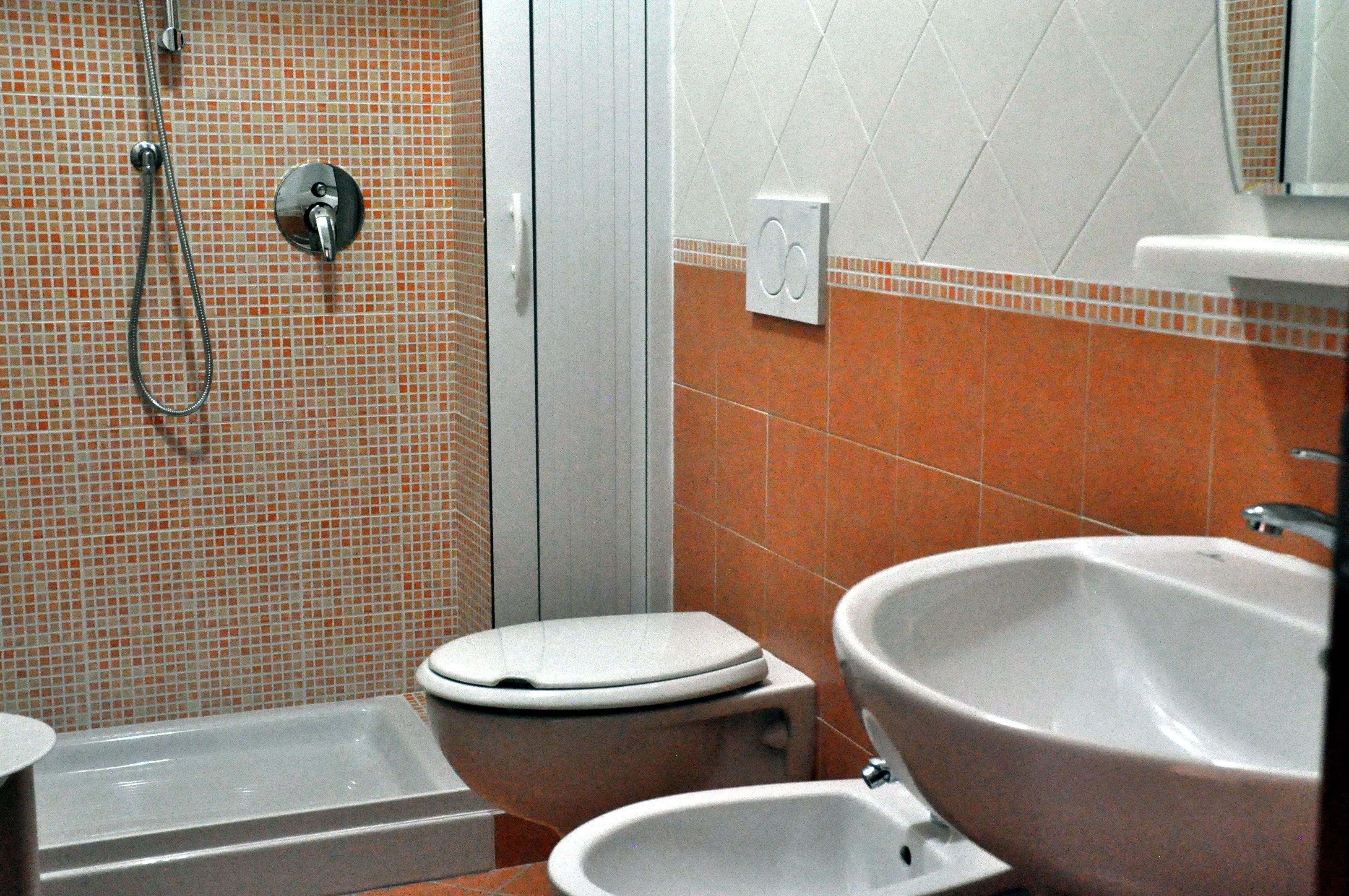 A bathroom with a shower, toilet, and sink.