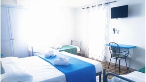 Une chambre d’hôtel avec deux lits, un bureau et une chaise.