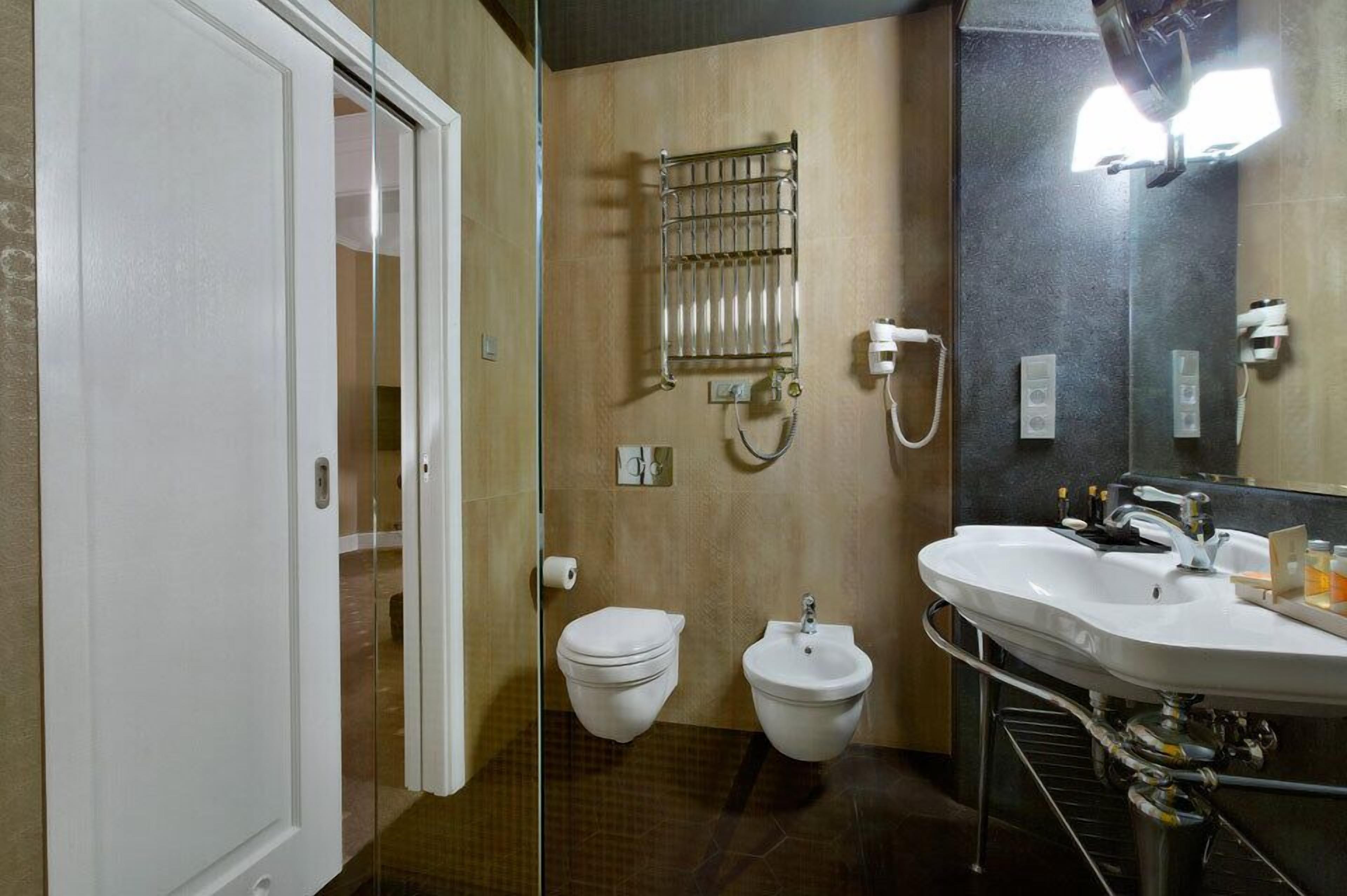 A bathroom with a toilet, bidet, and sink.