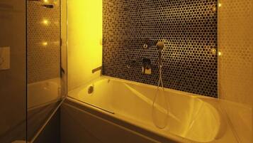 A bathroom with a bathtub, a shower, and a glass-enclosed shower area.