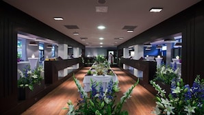 A long, narrow hotel corridor with a central table adorned with flowers and a white tablecloth. - Bristol ART & Medical SPA (Busko-Zdroj)
