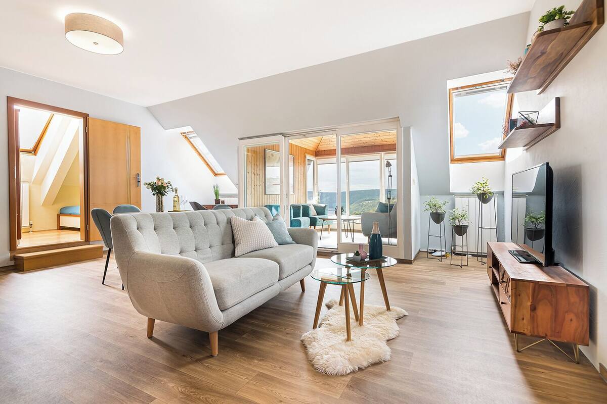 A modern living room with a sofa, coffee table, and TV stand.