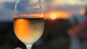 Un verre de vin blanc, avec le soleil couchant en arrière-plan.