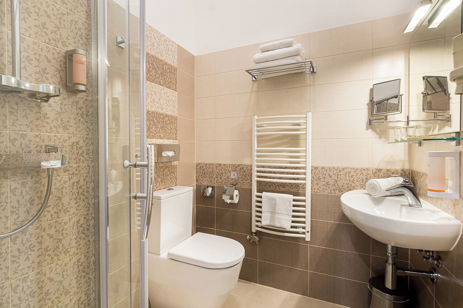 A modern bathroom with a glass shower enclosure, a toilet, a towel rack, and a sink with a mirror.