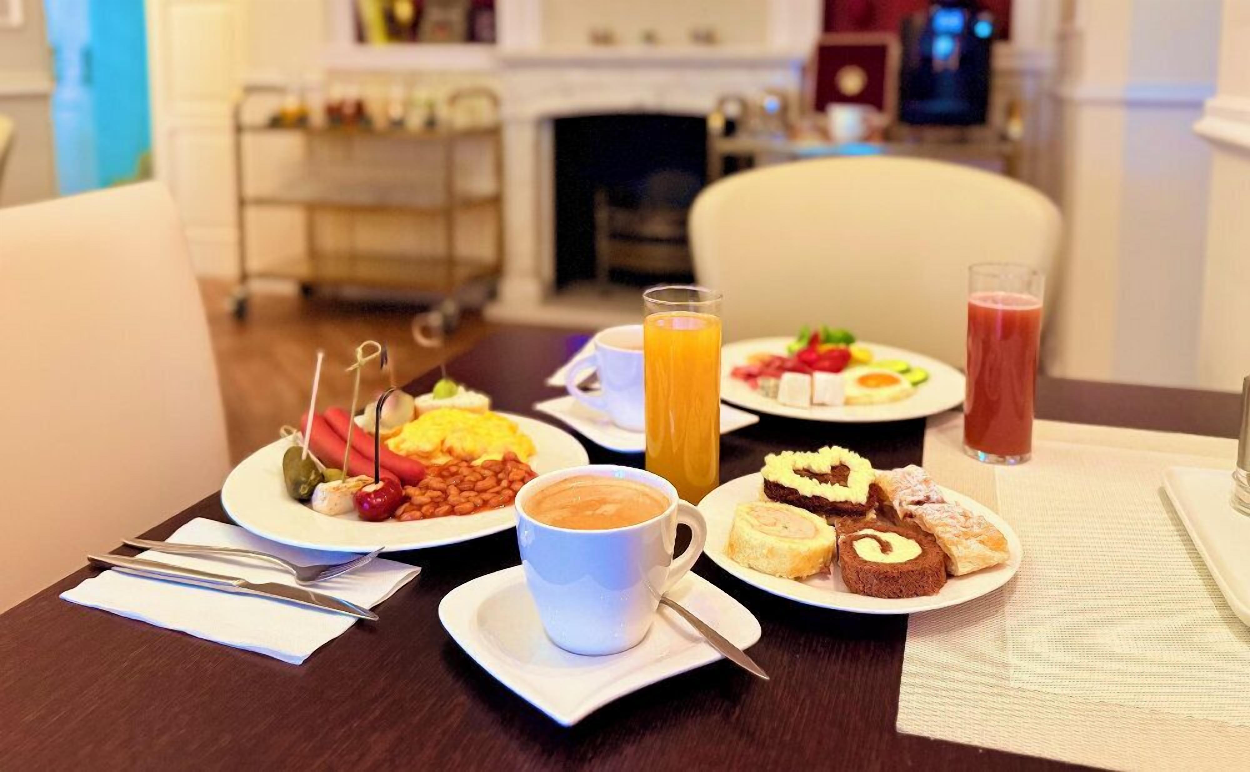 A breakfast setting with plates of food, a coffee cup, and a glass of orange juice.