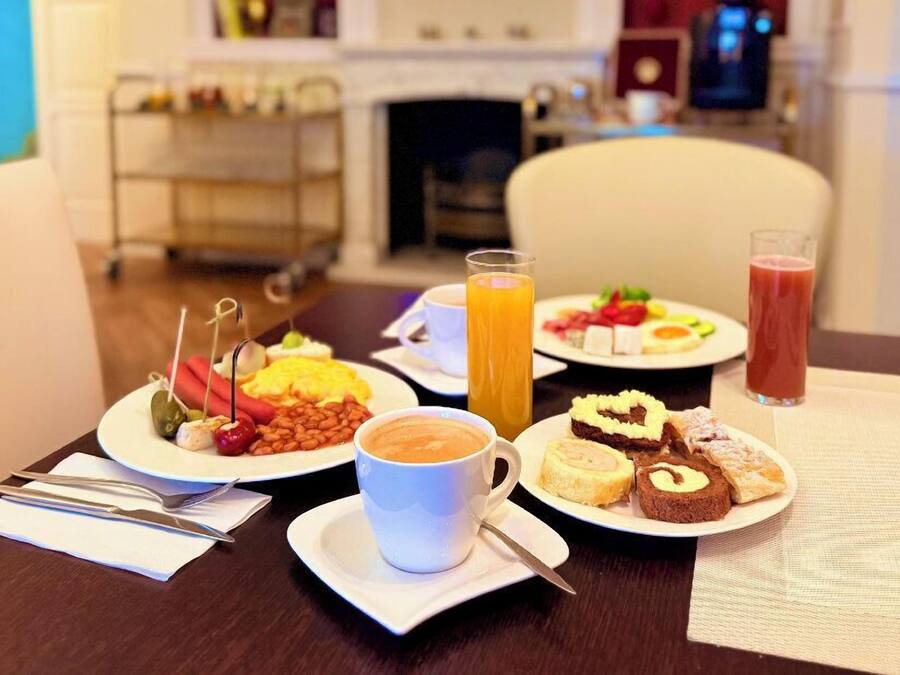 A breakfast setting with plates of food, a coffee cup, and a glass of orange juice.