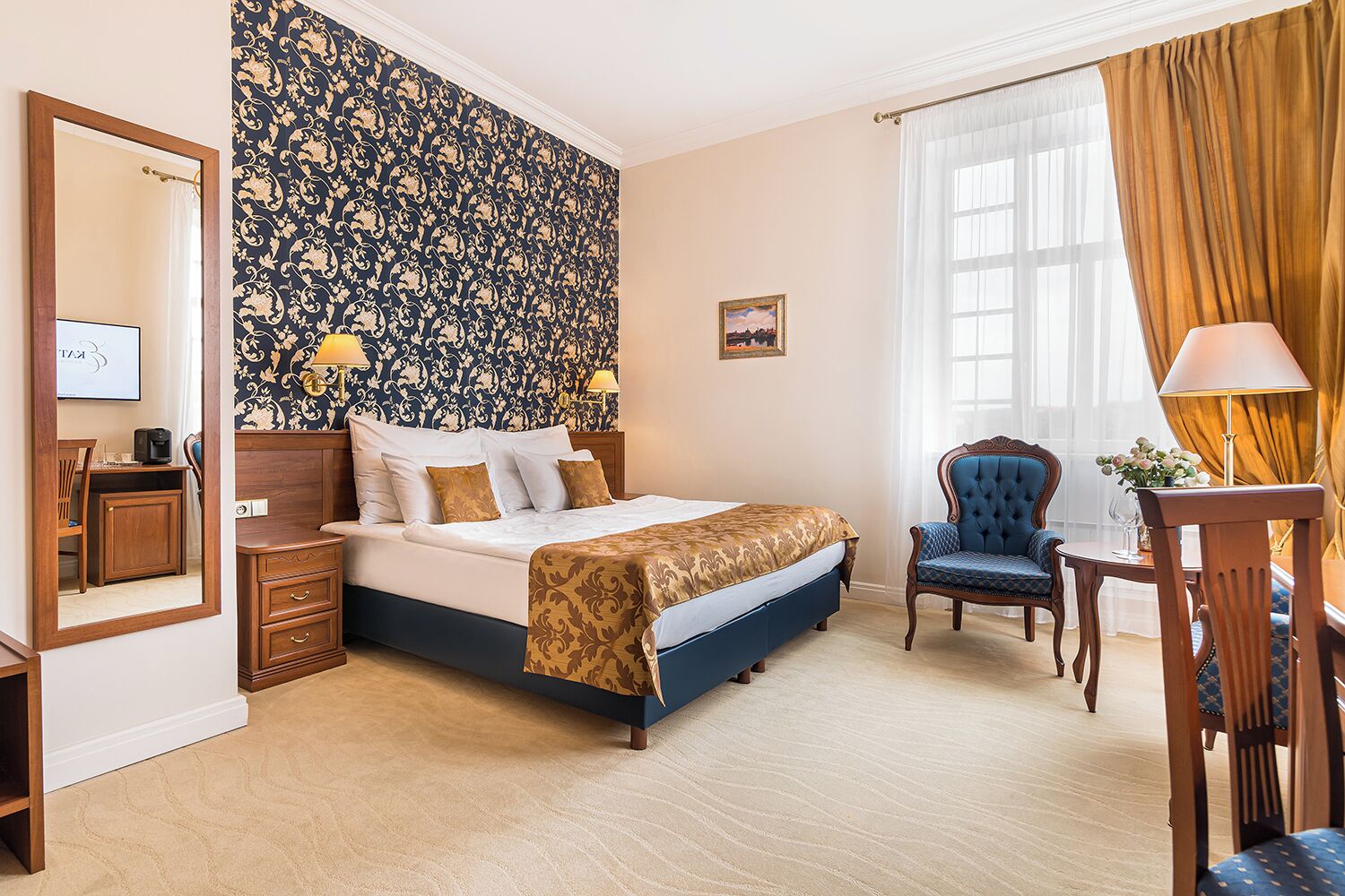 Une chambre d’hôtel avec un grand lit, un bureau, une chaise et un miroir.