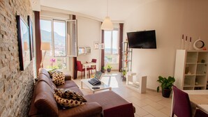 Una sala de estar moderna con un sofá, una mesa de centro, un televisor y un comedor.