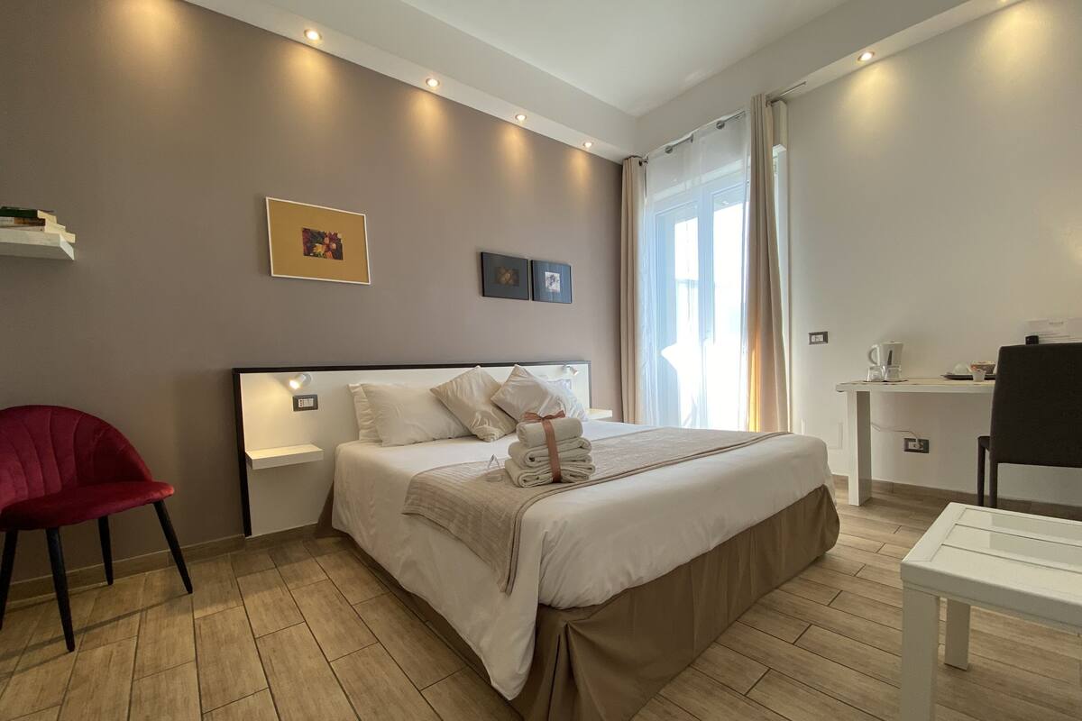 Una habitación de hotel moderna con una cama grande, un escritorio y una silla.