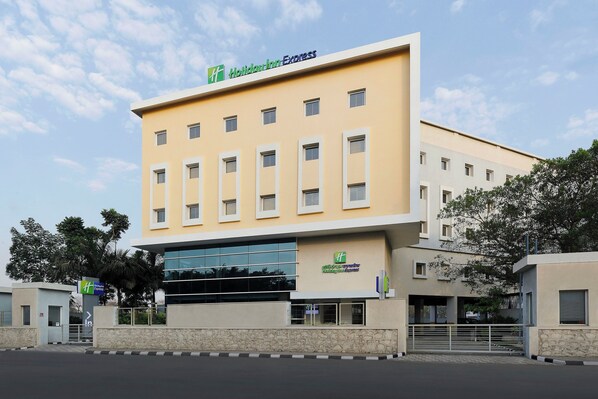 A multi-story building with a flat facade, a large entrance with a glass canopy, and multiple windows.