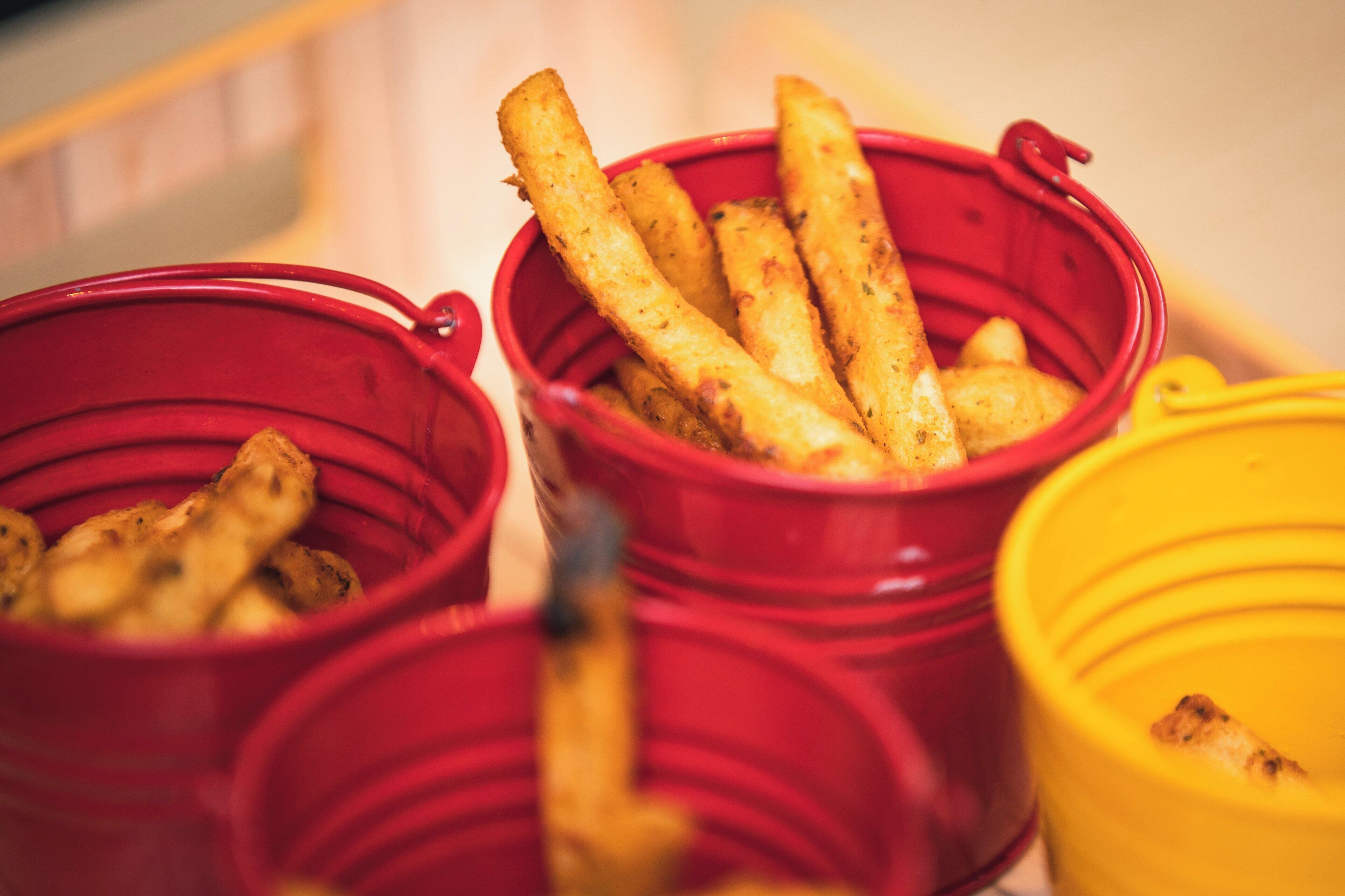 Drei rote Behälter mit Lebensmitteln, vermutlich in einer Buffet-Anlage.